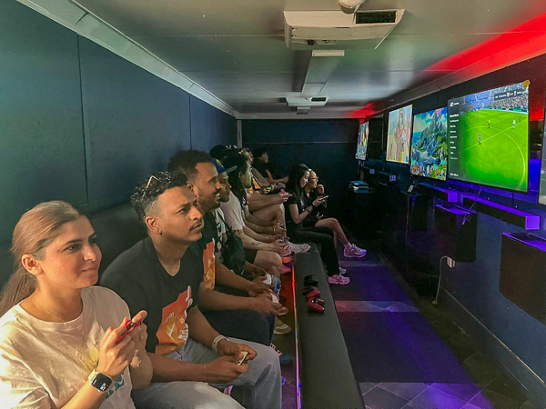Adults playing multiplayer games inside a video game truck at a corporate event Adults playing multiplayer games inside a video game truck at a corporate event