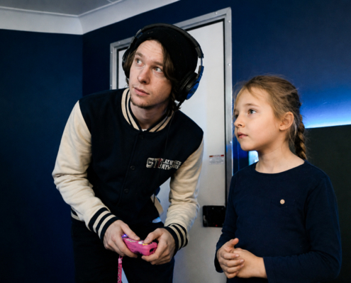 Game Coach helping a child during a video game party