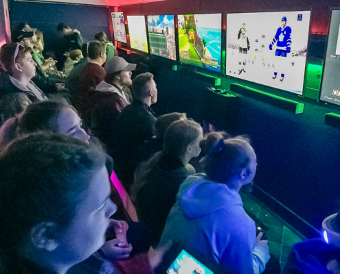 Corporate team playing multiplayer games inside gaming trailer