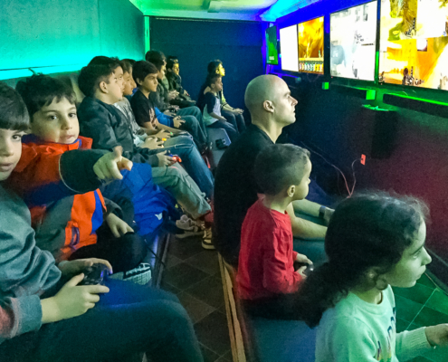 Kids playing multiplayer video games on large gaming screens