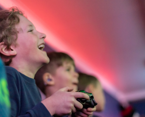 Happy kids playing video games at a gaming party