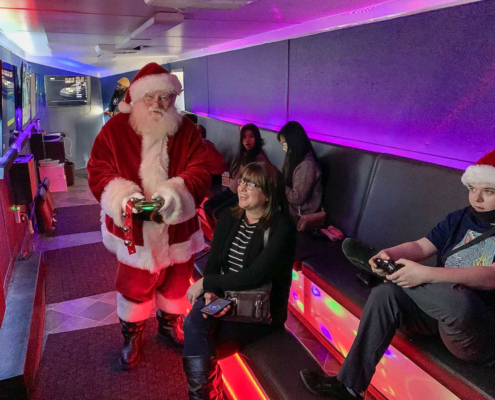 Santa visiting kids inside GameTrucks GT gaming trailer
